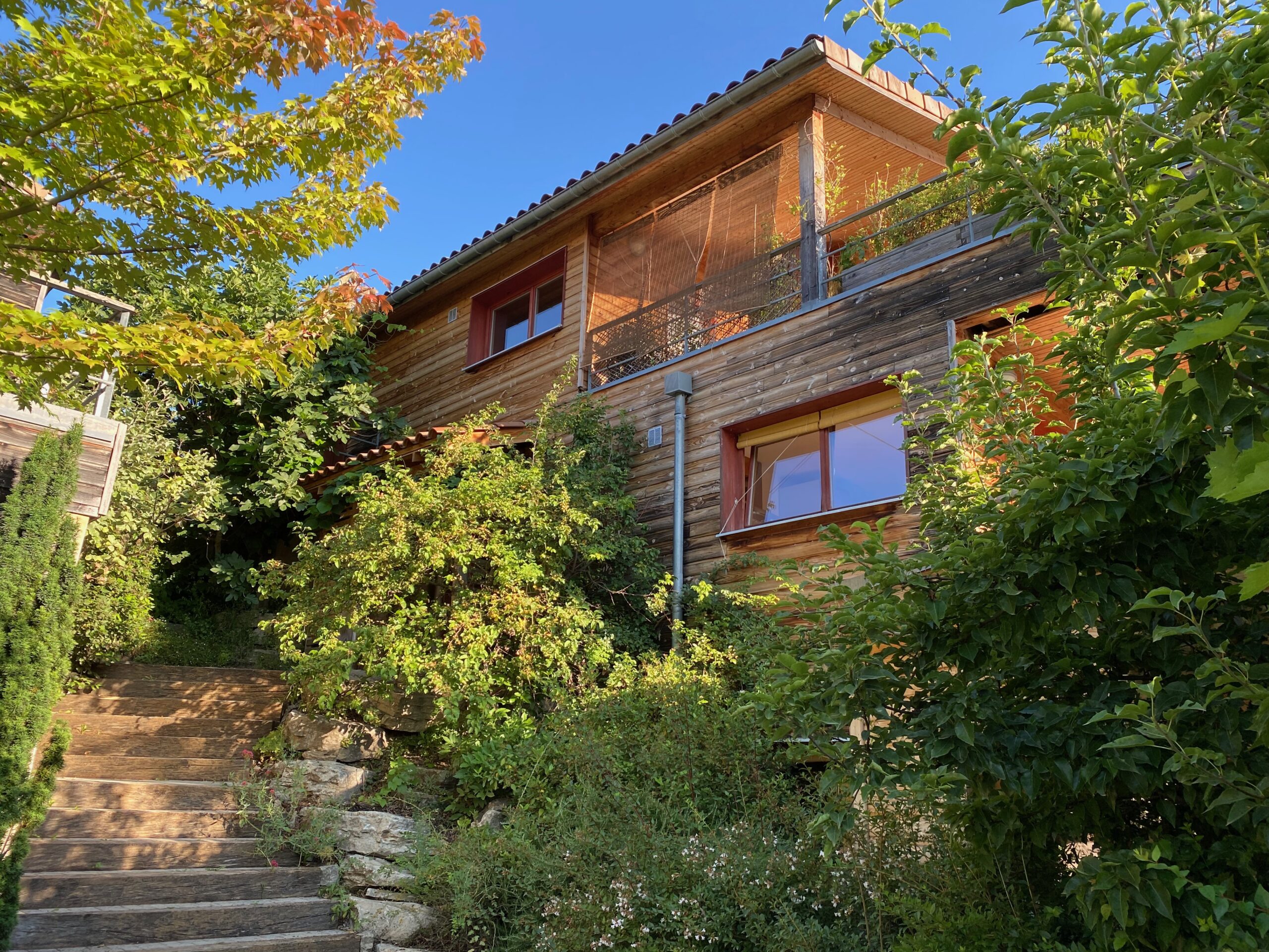 La Maison Commune d'Habiterre, maison en bois dans la verdure